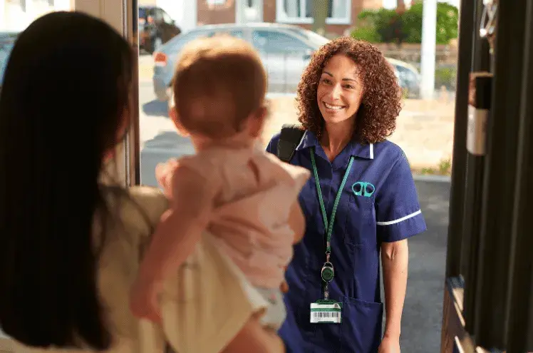 a mum opens the door to a midwife